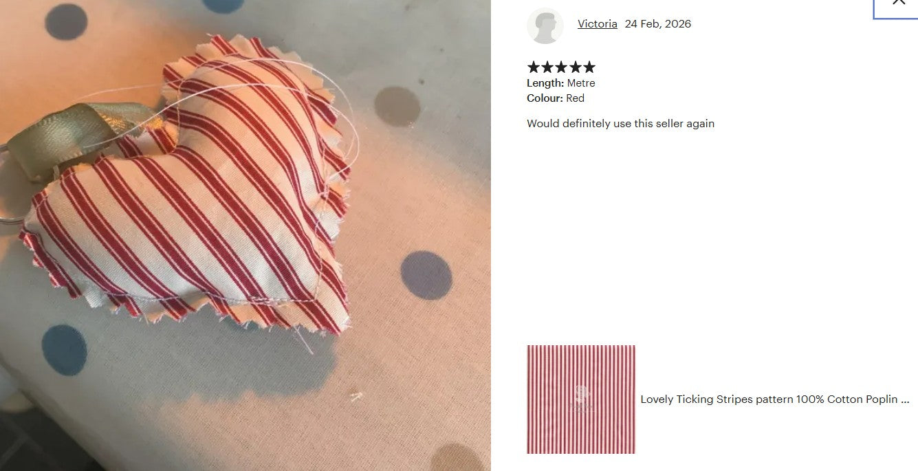 Heart-shaped pillow with red and white striped pattern on a polka dot background